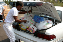 Grateful community member stocks up on necessities received at the Bass distribution line.