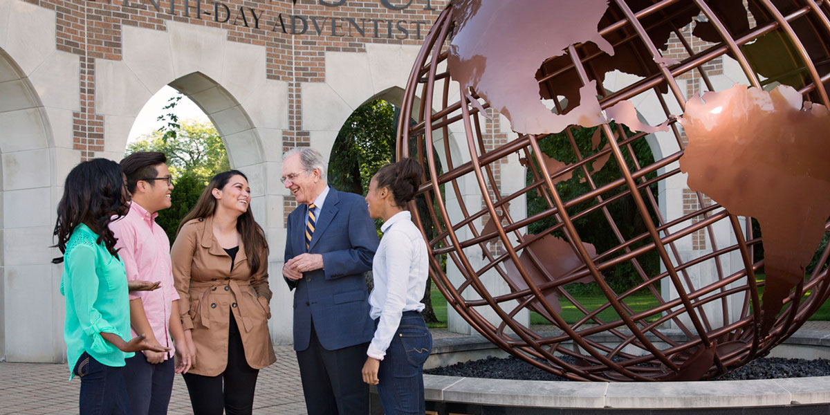 President Andreasen with students at the Andrews globe entrance